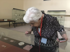 Lamia looking at the cylinder seals displayed at the Iraq Museum. Image provided by NPR.